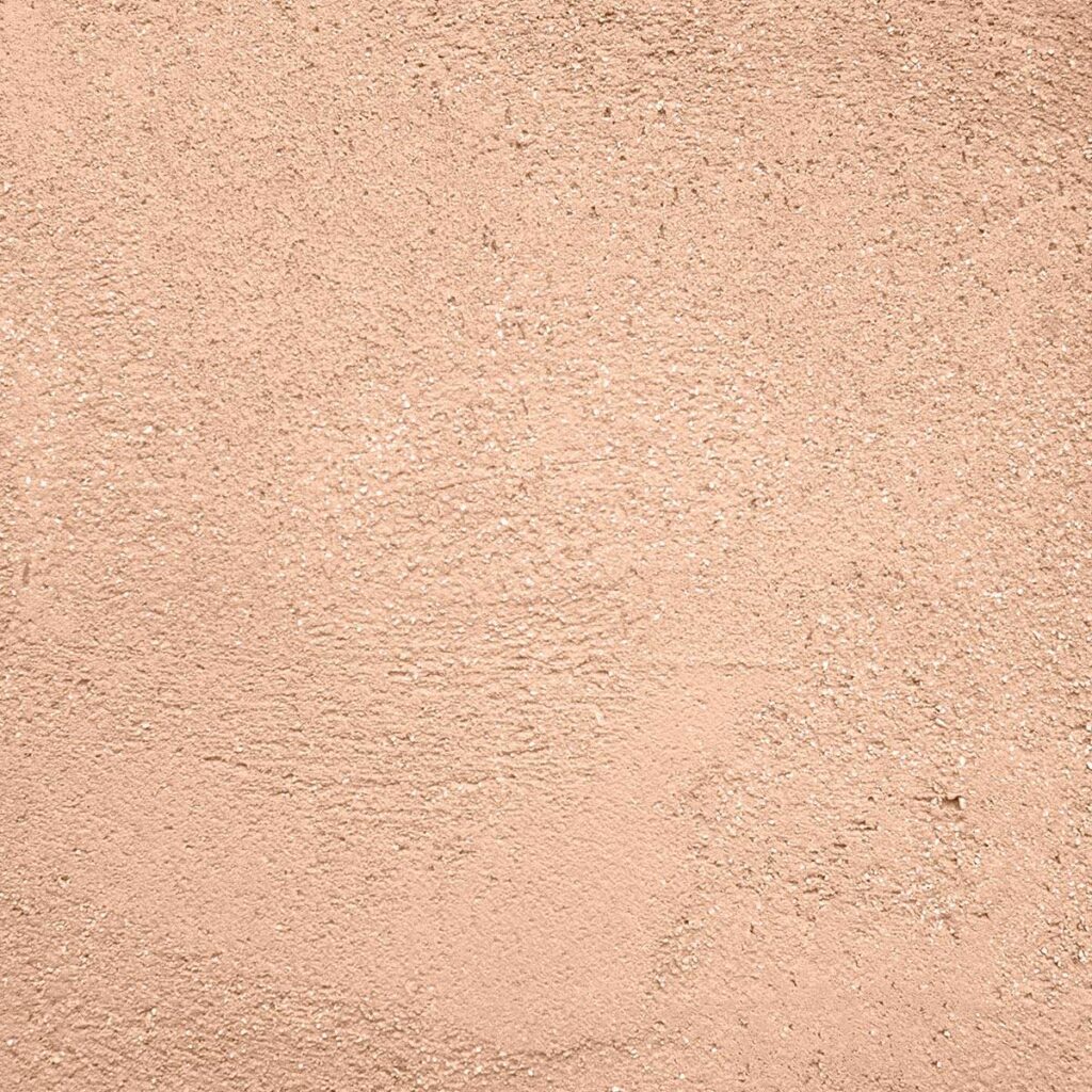 Texture crépis granulaire beige rosé pour murs extérieurs. Mur extérieur en crépis granulaire de couleur beige rosé pâle. Surface texturée rugueuse idéale pour un arrière-plan décoratif.